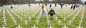 Family members walk through the field of remembrance looking for the names on crosses of those who died in World War One at the commemoration of Armistice Day at the Auckland War memorial. Photograph / Greg Bowker