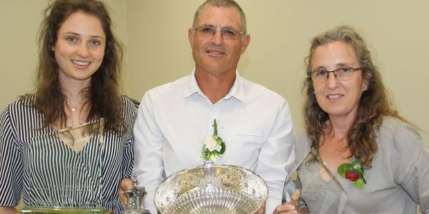 Rose breeder Rob Somerfield gets help from wife Linda and daughter Amanada to carry the many award he received on Sunday, including the Pacific Rose Bowl. Photo / Peter Tiffany