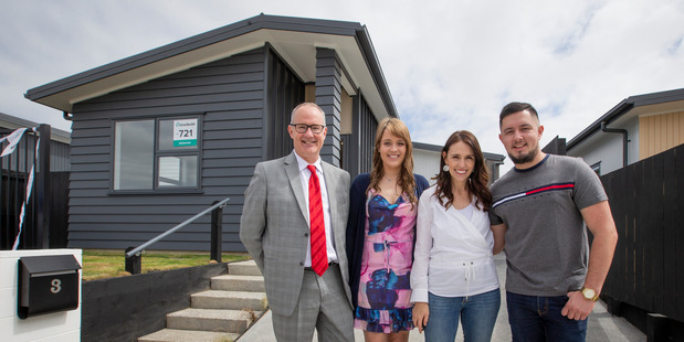 Minister Phil Twyford and new KiwiBuild home owners Derryn Jayne and Fletcher Ross stand with PM Jacinda Ardern outside their Papakura Home. Photo / Greg Bowker