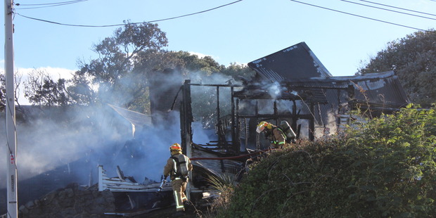 Firefighters at the aftermath of a house fire in Paekakariki.